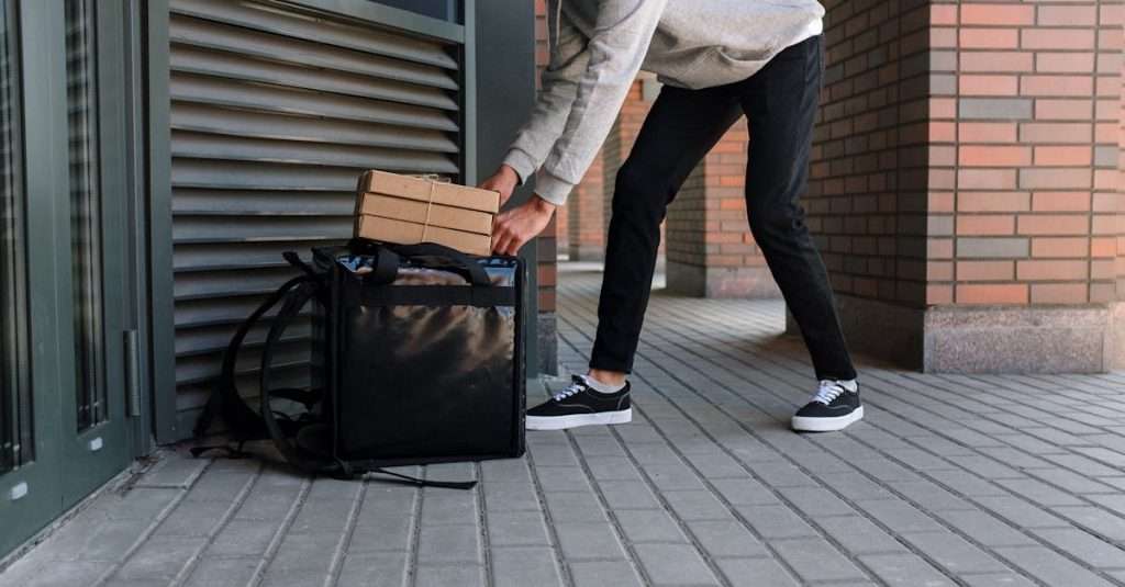 Man in White Dress Shirt and Blue Denim Jeans Holding Black Luggage Bag
